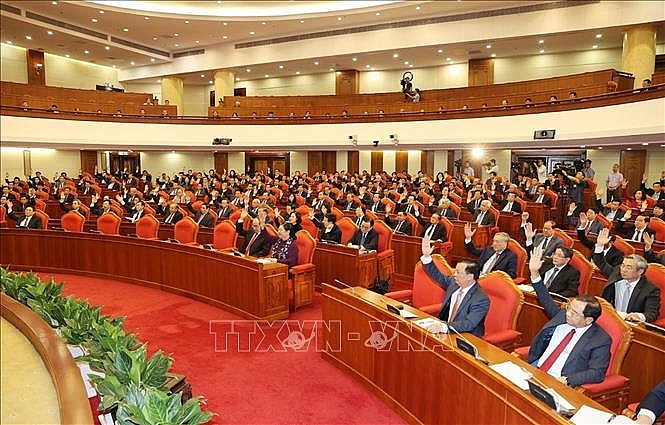 Các đồng chí lãnh đạo Đảng, Nhà nước và các đại biểu biểu quyết thông qua chương trình Hội nghị. Ảnh: Trí Dũng/TTXVN 5643 hoi nghi 051020a