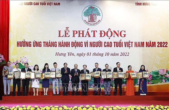 Chủ tịch nước Nguyễn Xuân Phúc và Chủ tịch Hội Người Cao tuổi Việt Nam Nguyễn Thanh Bình tặng bằng vinh danh và quà lưu niệm cho các tập thể và cá nhân tích cực hưởng ứng, đóng góp cho công tác chăm sóc đời sống vật chất và tinh thần cho người cao tuổi. Ảnh: Thống Nhất/TTXVN
