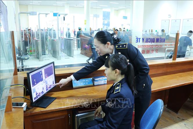 C&aacute;n bộ Trung t&acirc;m Kiểm dịch Y tế Quốc tế Quảng Ninh kiểm tra tr&ecirc;n m&aacute;y đo th&acirc;n nhiệt từ xa v&agrave; quan s&aacute;t t&igrave;nh trạng sức khỏe của h&agrave;nh kh&aacute;ch nhập cảnh từ Trung Quốc v&agrave;o Việt Nam tại cửa khẩu M&oacute;ng C&aacute;i (th&agrave;nh phố M&oacute;ng C&aacute;i, tỉnh Quảng Ninh). Ảnh: Minh Đ&ocirc;ng/TTXVN