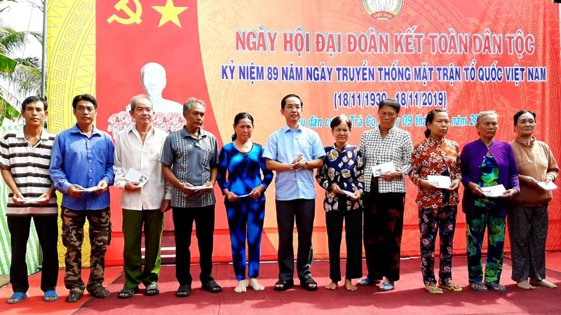 : &Ocirc;ng Hồ Thanh Thủy, B&iacute; thư Huyện ủy H&ograve;a B&igrave;nh (người đứng giữa), tặng qu&agrave; cho c&aacute;c gia đ&igrave;nh ch&iacute;nh s&aacute;ch.