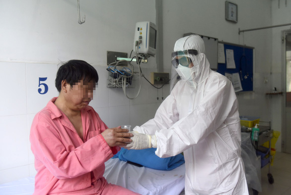 &Ocirc;ng Li Ding (b&igrave;a tr&aacute;i) được c&aacute;c b&aacute;c sĩ Bệnh viện Chợ Rẫy chăm s&oacute;c trong ph&ograve;ng c&aacute;ch ly đặc biệt.