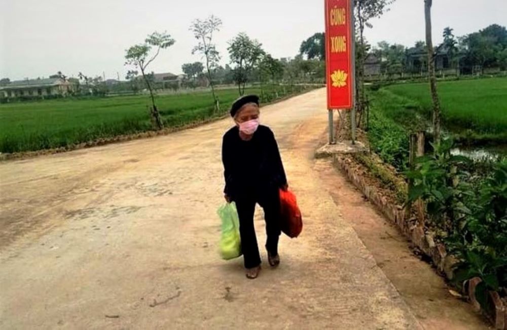 Mẹ liệt sĩ Nguyễn Thị Ba đi bộ mang gạo, rau đến ủng hộ. Ảnh IT