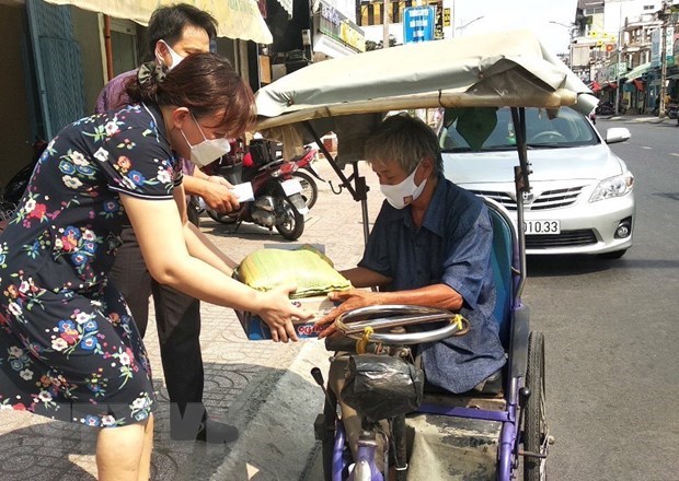 Trao qu&agrave; cho người b&aacute;n v&eacute; số dạo. (Ảnh: L&ecirc; Th&uacute;y Hằng/TTXVN)
