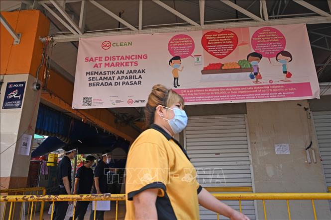 Người d&acirc;n đeo khẩu trang ph&ograve;ng l&acirc;y nhiễm dịch COVID-19 tại một chợ ở Singapore, ng&agrave;y 22/4. Ảnh: AFP/TTXVN