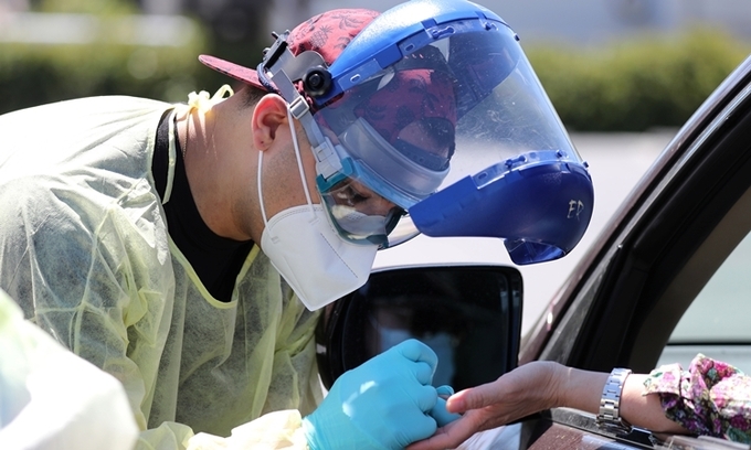 Nh&acirc;n vi&ecirc;n y tế tại một trạm x&eacute;t nghiệm ở Los Angeles ng&agrave;y 24/4. Ảnh: Reuters.