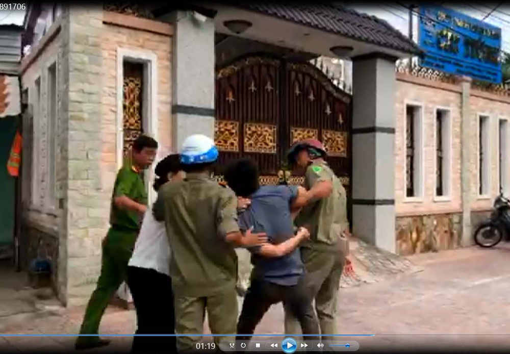 &Ocirc;ng Nguyễn Khắc Vĩnh bị c&ograve;ng tay như tội phạm. (Ảnh từ Clip)