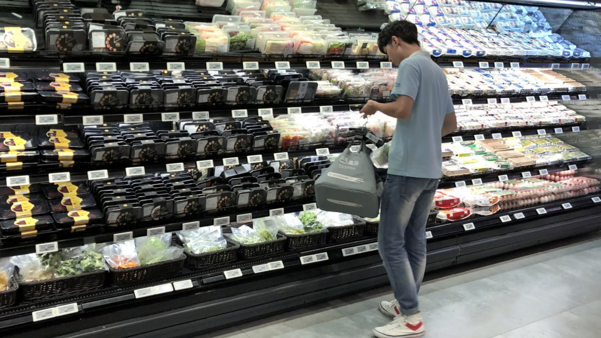 Nh&acirc;n vi&ecirc;n của si&ecirc;u thị Hema đang lấy c&aacute;c h&agrave;ng h&oacute;a do kh&aacute;ch h&agrave;ng đặt, cho v&agrave;o giỏ h&agrave;ng v&agrave; chuyển đến kh&acirc;u tiếp theo bằng hệ thống băng chuyền lắp đặt tr&ecirc;n trần