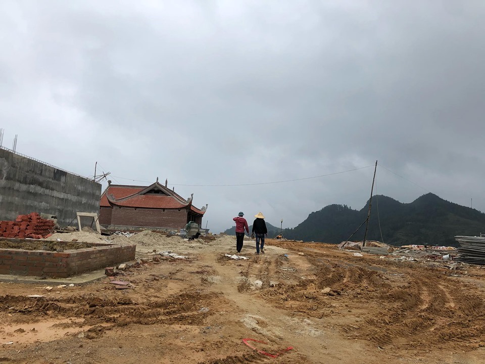 Con đường dẫn v&agrave;o khu dự &aacute;n rộng 33m, d&agrave;i 1,7km qua c&aacute;nh đồng v&agrave;o ch&ugrave;a đ&atilde; giải ph&oacute;ng mặt bằng. C&aacute;c hạng mục như Đền Hộ Quốc, cầu thang, s&acirc;n b&atilde;i đang được thi c&ocirc;ng, c&ograve;n rất ngổn ngang.