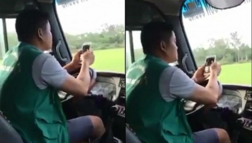 Tài xế dùng khuỷu tay lái xe, tay bấm điện thoại 