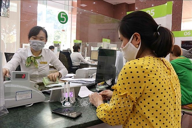 Khách hàng giao dịch tại Ngân hàng Vietcombank chi nhánh Bắc Ninh.  	Ảnh TTXVN